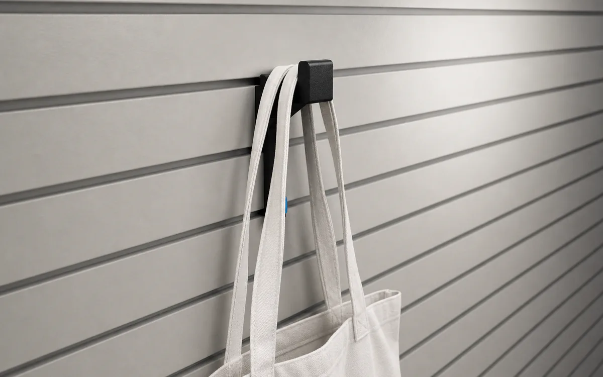 Long locking bag hook on slatwall, holding a canvas tote bag by its handles