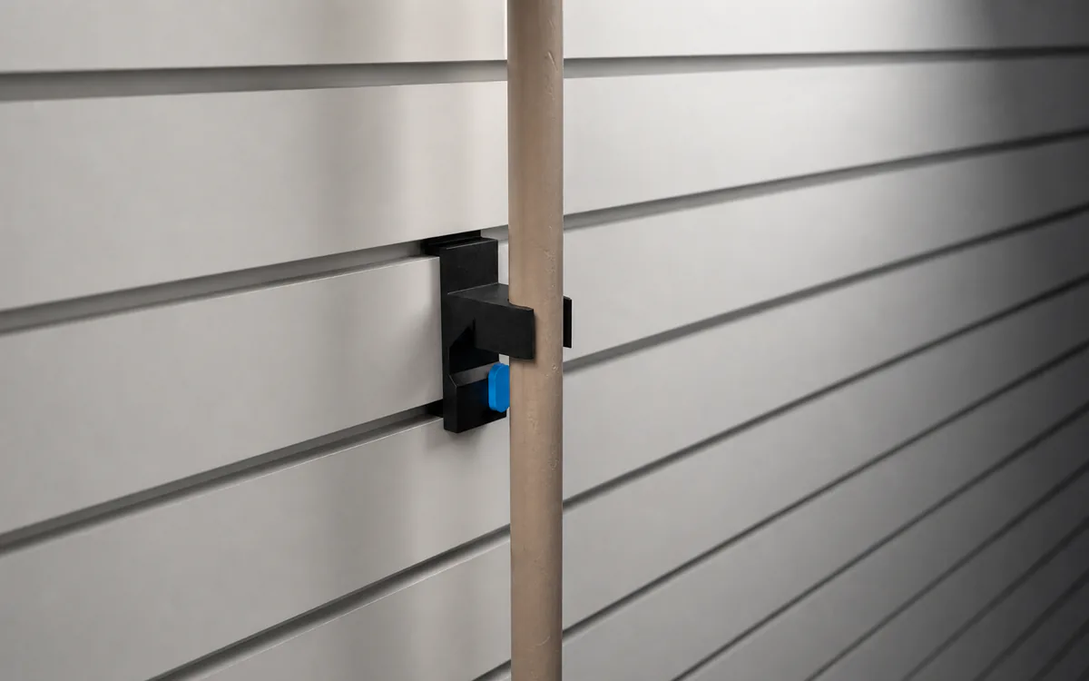 Broom & mop gripper on slatwall, holding a broom handle